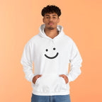 Person wearing a white hoodie with a smiley face design on an orange background